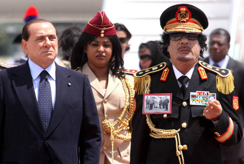Muammar al-Gaddafi am 10. Juni 2009 in Italien mit dem italienischen Premierminister Silvio Berlusconi und seiner Leibwächterin