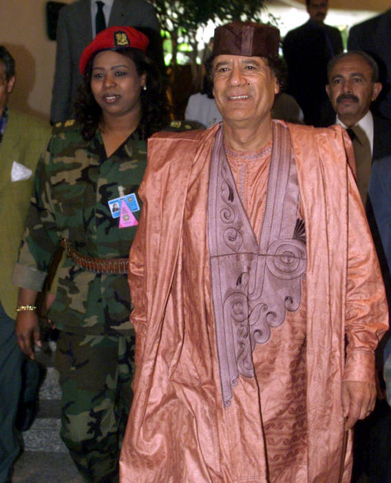 Muammar al-Gaddafi am 4. April 2000 in Kairo (Ägypten) bei der Ankunft im Sheraton Hotel mit seiner Leibwächterin und dem EU-Präsidenten Antonio Guterres
