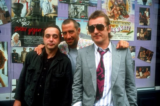 Trio 1985. - Im Hintergrund ein Kinoplakat zum Film Drei gegen drei (1985)
