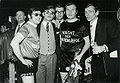 Karel van Herck (Manager), Johan Stolz (belgischer Sänger), Tony Bloemen (PR Manager von Arcade), ein Mitarbeiter von Arcade, Marc Dex (belgischer Popsänger) und Louis van Rijmenant (Produzent) 1968 im Sportpaleis Antwerpen während der "Nacht der Naastenliefde"